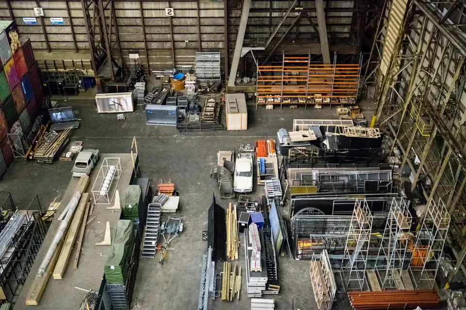 Bedrijfshal van binnen met stellingen en materialen